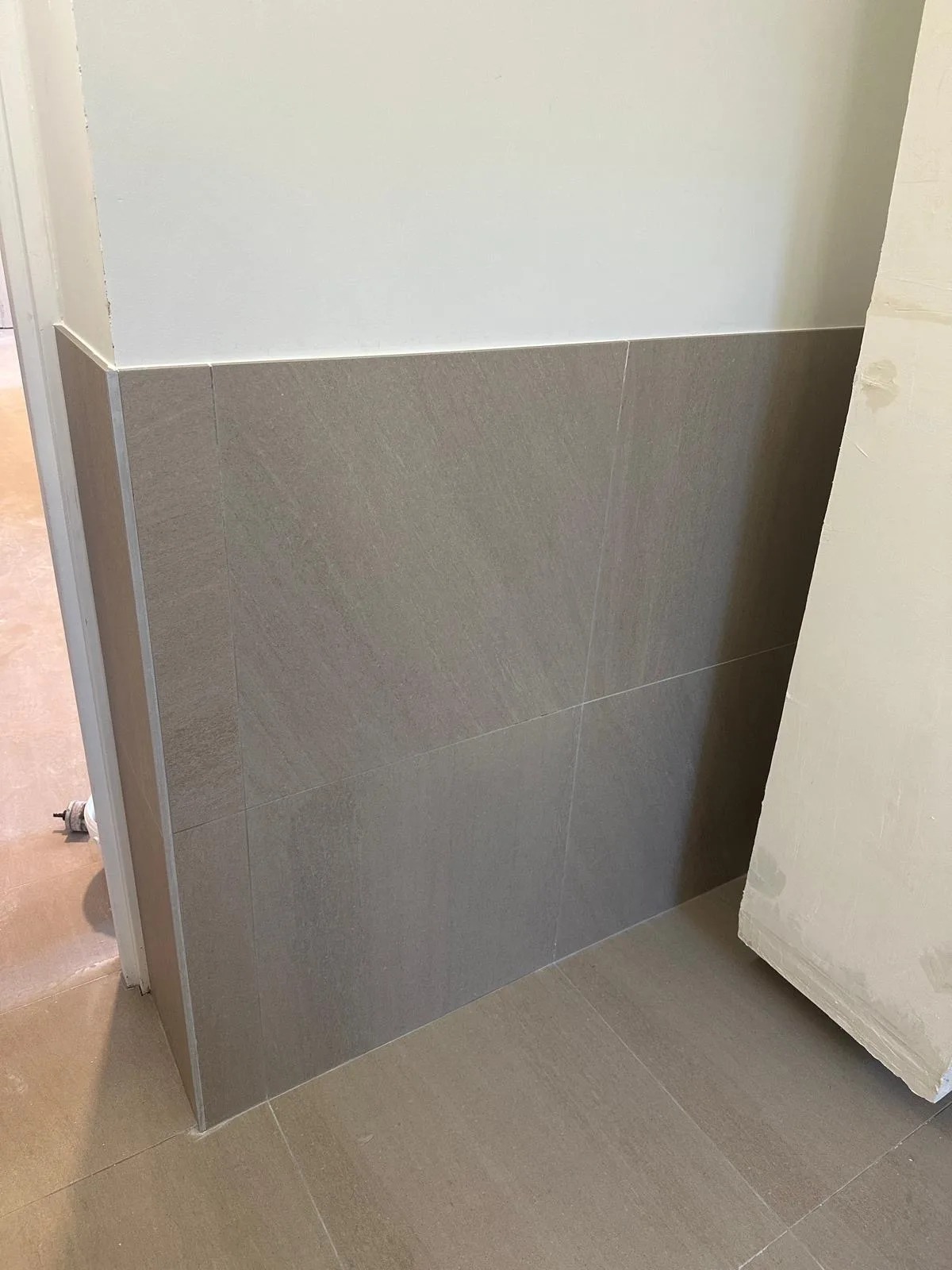 Détail de carreaux gris posés au mur et au sol
