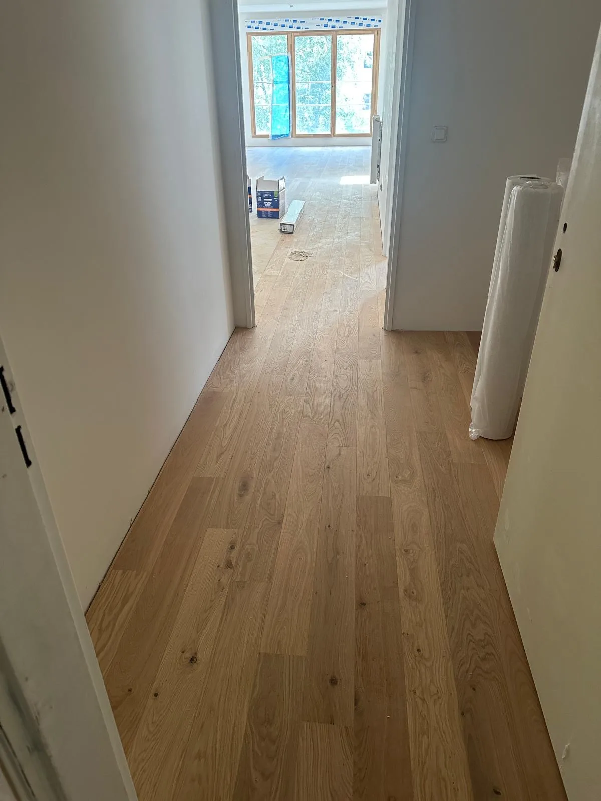 Parquet posé dans un passage avec du matériel de chantier encore présent